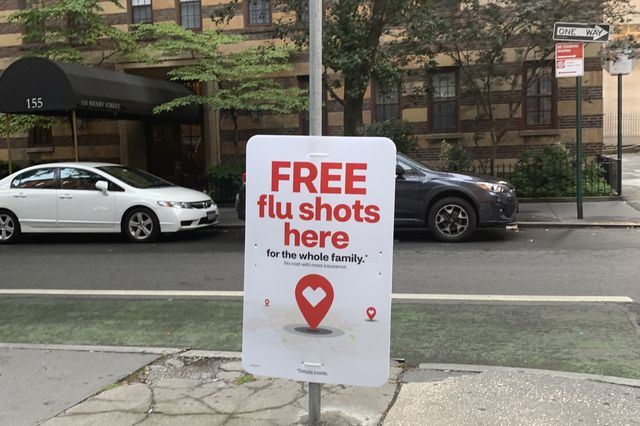 A sign saying flu shots are available at a CVS